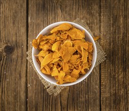 Sweet Potato Chips on an old wooden table as detailed close-up shot, selective focus