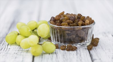 Vintage wooden table with Raisins (selective focus, close-up shot)