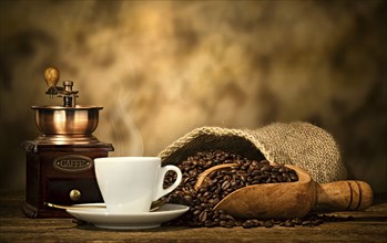 Cup of espresso coffee, coffee beans and old coffee grinder on the wooden table