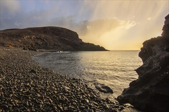 A beautiful rocky bay in the morning at sunrise. Cliffs and rocky beach with a view of the Atlantic