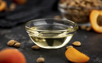 Portion of Apricot Oil with some fresh fruits as detailed close up shot (selective focus)