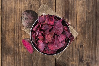 Wooden table with Beetroot Chips (detailed close-up shot, selective focus)