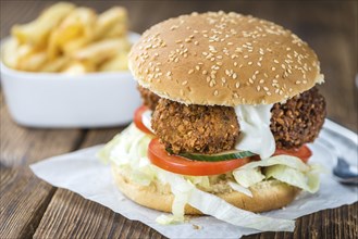 Homemade Falafel Burger (detailed close-up shot, selective focus) on a wooden table