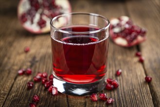 Pomegranate juice on a vintage background as detailed close-up shot (selective focus)