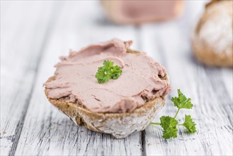 Roll with Liverwurst (German cuisine) on an old wooden table as detailed close-up shot (selective