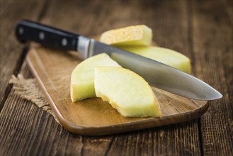 Honeydew Melon on an old wooden table as detailed close-up shot (selective focus)