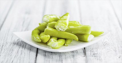 Fresh made Green Chilis (filled with cheese) on an old and rustic wooden table (selective focus,