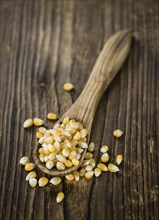 Portion of Corn (detailed close-up shot) on wooden background (selective focus)