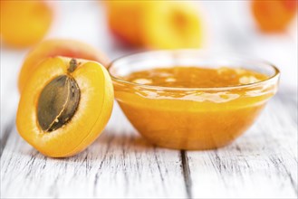 Apricot Jam on an old wooden table as detailed close-up shot (selective focus)