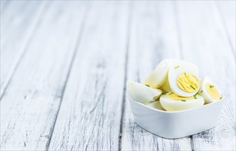 Wooden table with halved Eggs (selective focus, close-up shot)