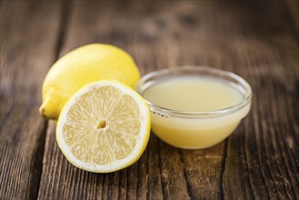 Homemade Lemon Juice on an wooden table (selective focus) as detailed close-up shot