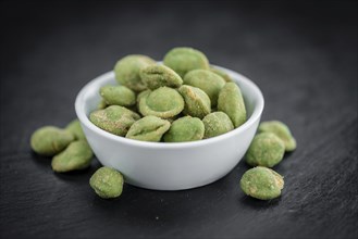 Some fresh Wasabi Peanuts on a vintage slate slab (selective focus, close-up shot)