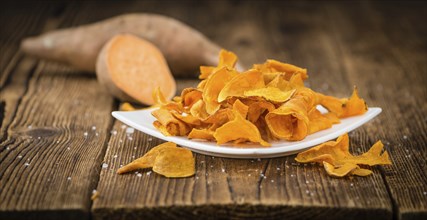 Sweet Potato Chips on a vintage background as detailed close-up shot, selective focus