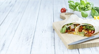 Chicken Wraps on a wooden table as detailed close-up shot (selective focus)