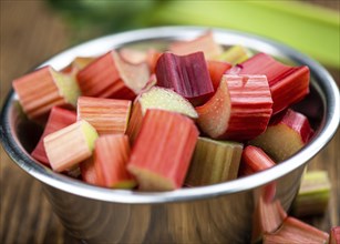 Chopped Rhubarb on an old wooden table (close up shot, selective focus)