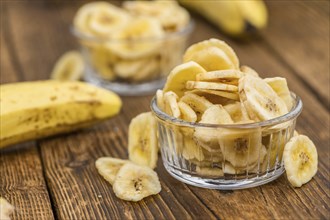 Fresh made Dried Banana Chips on an old and rustic wooden table, selective focus, close-up shot