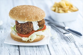 Wooden table with a homemade Falafel Burger (selective focus)