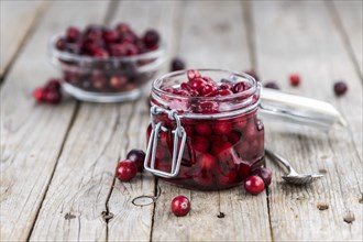 Vintage wooden table with Cranberries (preserved) (selective focus, close-up shot)