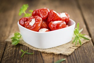 Fresh made Red Pepper (stuffed with cheese) on an old and rustic wooden table (selective focus,