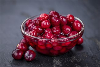 Some healthy Preserved Cranberries on a vintage slate slab (selective focus)