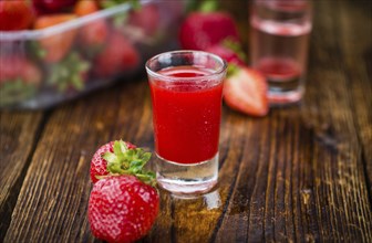 Fresh made Strawberry liqueur on an old and rustic wooden table, selective focus, close-up shot