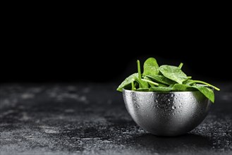 Vintage looking table with fresh Spinach (detailed close-up shot, selective focus)