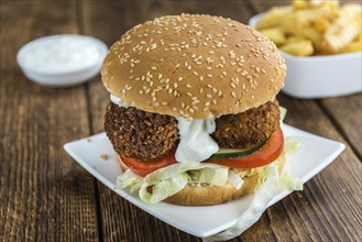 Fresh madeFalafel Burger on wooden background (close-up shot, selective focus)