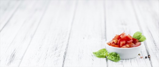 Cutted Tomatoes on an old wooden table as detailed close-up shot (selective focus)