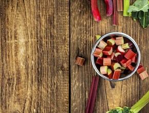 Chopped Rhubarb on an old wooden table (close up shot, selective focus)