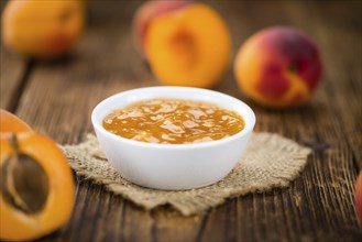 Apricot Jam on an old wooden table as detailed close-up shot (selective focus)