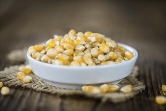 Portion of Corn (detailed close-up shot) on wooden background (selective focus)