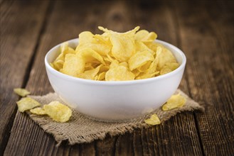 Cheese and Onion Potato Chips on a vintage background as detailed close-up shot (selective focus)