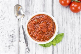 Fresh made Pasta Sauce (Tomato taste) on a vintage background (close-up shot)