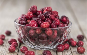 Dried Cranberries on an old wooden table (selective focus)