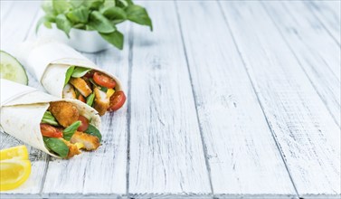 Portion of Chicken Wraps (selective focus) on an old wooden table