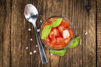 Homemade Diced Tomatoes on an wooden table (selective focus) as detailed close-up shot