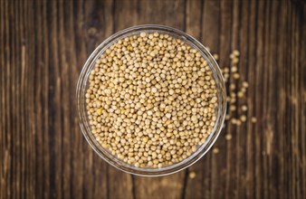 Seeds (Mustard) as high detailed close-up shot on a vintage wooden table (selective focus)