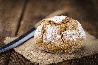 Fresh made Wholemeal Bun on a vintage background (close-up shot)