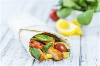 Chicken Wrap (detailed close-up shot, selective focus) on wooden background