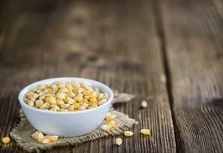 Dried Corn (detailed close-up shot, selective focus) on vintage wooden background