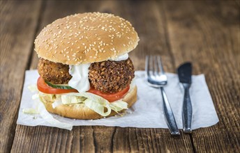 Wooden table with a homemade Falafel Burger (selective focus)