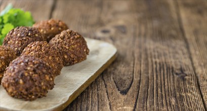 Portion of Falafel on an old wooden table (close-up shot, selective focus)