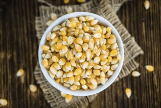 Dried Corn (detailed close-up shot, selective focus) on vintage wooden background