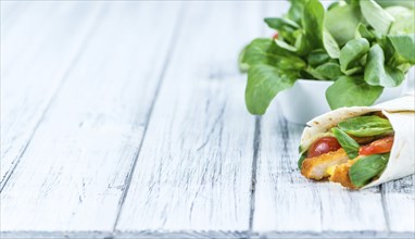 Chicken Wraps on a wooden table as detailed close-up shot (selective focus)