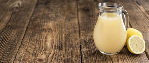 Fresh made Juice (lemon) on an old and rustic wooden table (selective focus, close-up shot)