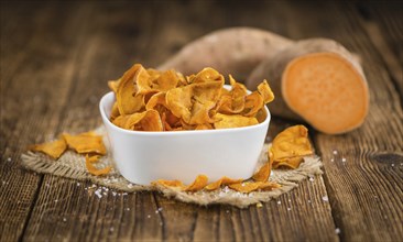 Homemade Sweet Potato Chips on vintage background selective focus, close-up shot