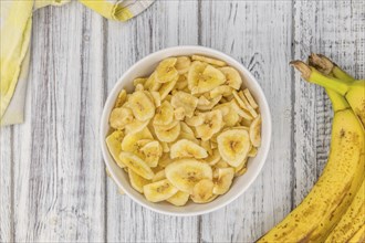 Fresh made Dried Banana Chips on an old and rustic wooden table, selective focus, close-up shot