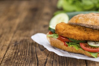 Old wooden table with a Chicken Schnitzel (selective focus, close-up shot)