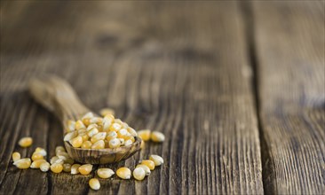 Dried Corn (detailed close-up shot, selective focus) on vintage wooden background