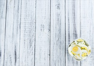 Halved Eggs on wooden background (close-up shot, selective focus)